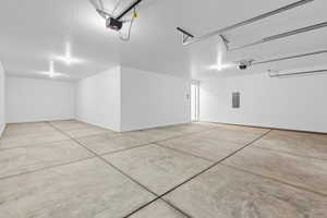 Garage featuring electric panel and a garage door opener