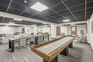 Recreation room with a drop ceiling and billiards table