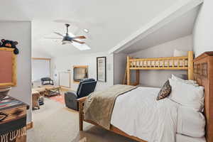Bedroom featuring vaulted ceiling, ceiling fan, carpet floors, and a skylight
