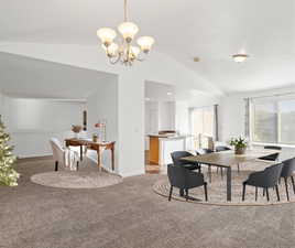 Dining room featuring vaulted ceiling, carpet floors, and a chandelier. Virtually staged