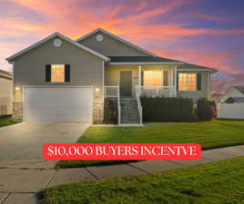 View of front facade with a porch, driveway, a front yard, and a garage