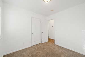 Unfurnished bedroom featuring carpet and baseboards
