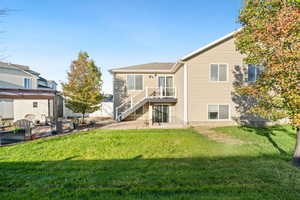 Rear view of house featuring a patio, stairs, and a lawn
