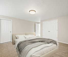 Bedroom featuring light colored carpet, a textured ceiling, and a closet