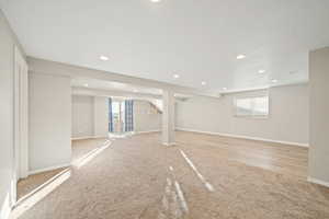 Below grade area with light carpet, plenty of natural light, and recessed lighting