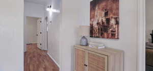 Hallway featuring a textured wall, dark wood-style floors, and arched walkways