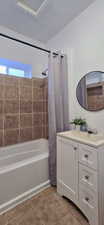Full bath with vanity, shower / tub combo, and light tile patterned floors