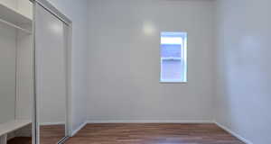 Unfurnished bedroom with wood finished floors and a closet