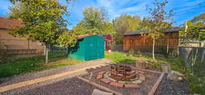Fenced backyard with a fire pit and a storage shed