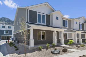 View of front of property featuring covered porch, brick siding, and a mountain view