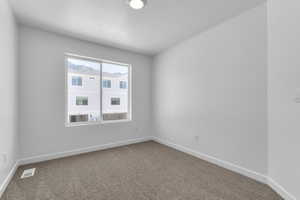 Carpeted spare room featuring baseboards and a textured ceiling
