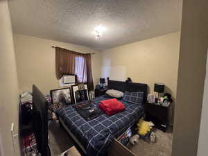 Bedroom with carpet floors and a textured ceiling