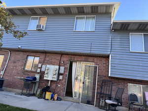 Back of house featuring brick siding and a patio