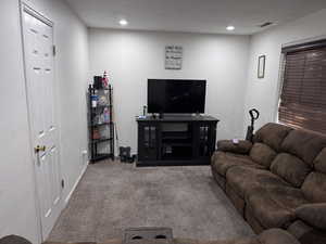 Living room with carpet flooring, a textured ceiling, and recessed lighting
