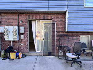 Entrance to property featuring brick siding and a patio area