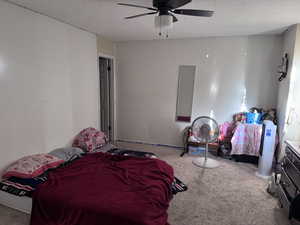 Bedroom with carpet flooring, a textured ceiling, and a ceiling fan