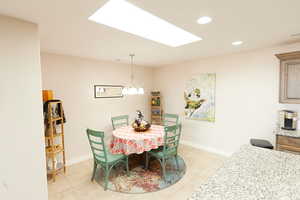 Dining area featuring recessed lighting, a skylight, a chandelier, and light tile patterned floors