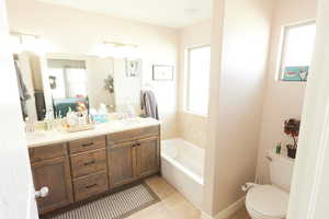 Full bathroom with a bath, double vanity, and light tile patterned flooring