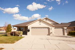 Ranch-style house featuring concrete driveway, a garage, and a front lawn