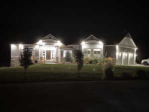 View of front facade with a yard and stone siding