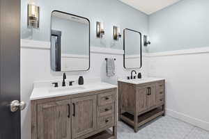Full bathroom with two vanities and tile floors