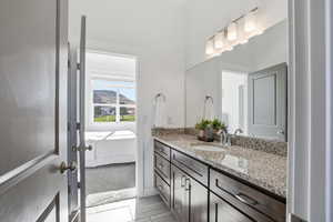 Ensuite jack-and-jill bathroom with vanity and dark cabinetry
