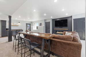 Living room with light carpet, recessed lighting, sconce lighting, and a fireplace