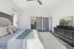 Bedroom featuring a barn door, carpet flooring, ensuite bathroom, recessed lighting, and a ceiling fan
