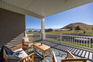 Balcony featuring a mountain view, an outdoor living space, and a view of countryside