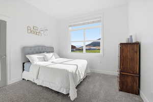 Carpeted bedroom featuring baseboards and mountain view