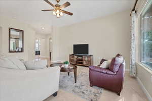 Living room featuring light tile patterned flooring, arched walkways, a ceiling fan, and recessed lighting