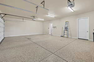 Garage featuring baseboards and a garage door opener