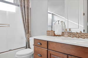 Full bath with shower / bath combination with glass door and vanity