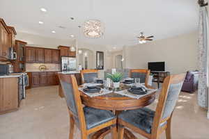 Dining room with arched walkways, ceiling fan, recessed lighting, light tile patterned floors, and a chandelier