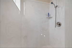 Full bath with a marble finish shower