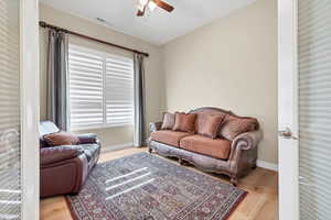 Living area with light wood finished floors and a ceiling fan