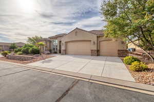 Mediterranean / spanish home with stone siding, a tiled roof, concrete driveway, and a garage