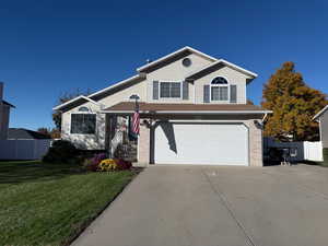 Traditional-style home featuring an attached garage, concrete driveway, and brick siding