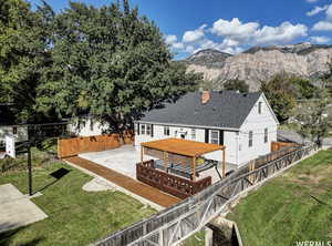 Rear view of house featuring a fenced backyard, a deck with mountain view, and a shingled roof
