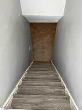 Staircase featuring baseboards and wood finished floors