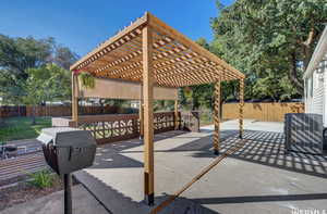 Fenced backyard featuring a patio and a pergola