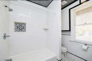 Full bath featuring shower / bathtub combination, tile walls, and tile patterned floors