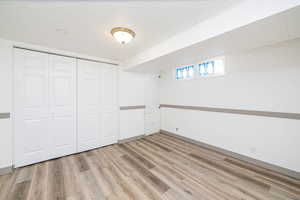 Unfurnished bedroom featuring light wood finished floors, a closet, and a textured ceiling