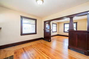 Empty room featuring light wood-style flooring, healthy amount of natural light, and a textured ceiling