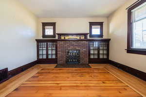 Unfurnished living room featuring a fireplace, wood-type flooring, plenty of natural light, and a textured ceiling
