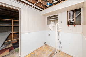 Washroom with electric dryer hookup and wooden walls