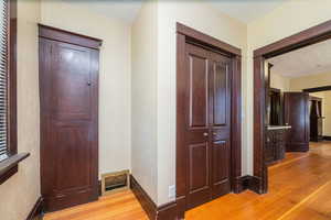 Corridor with light wood-style flooring and a textured ceiling