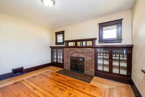 Unfurnished living room featuring a textured ceiling, wood-type flooring, and a fireplace