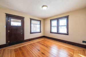 Entryway featuring wood-type flooring, healthy amount of natural light, and a textured ceiling