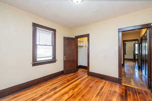 Unfurnished bedroom featuring dark wood finished floors and a textured ceiling
